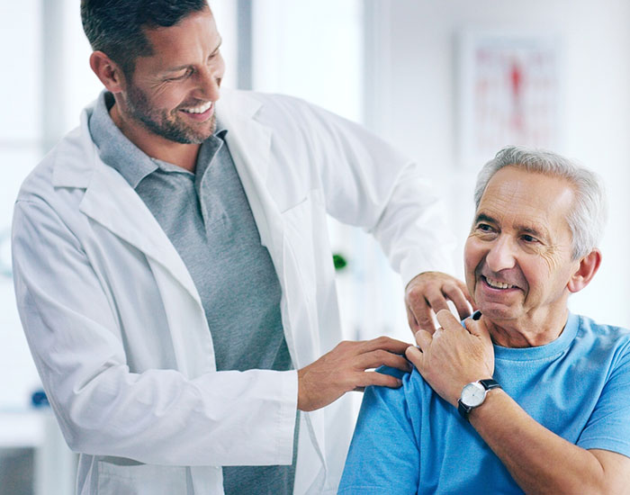male doctor doing some physiotherapy with a senior patient