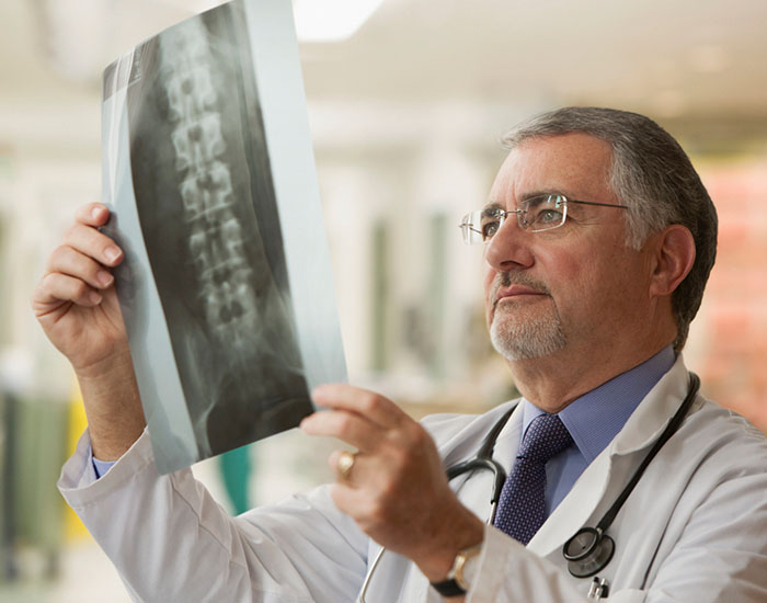 Elderly doctor looking at x-rays
